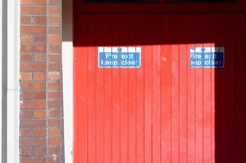 Fire exit keep clear sign on construction building site door Stock Photos