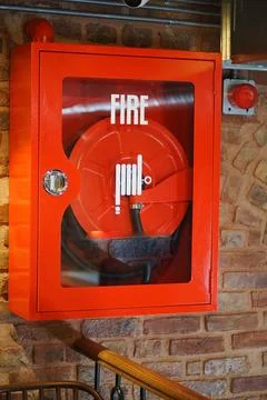 Fire extinguisher case on a brick wall in a building Stock Photos