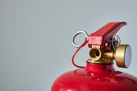 Fire extinguisher on a gray background. Close-up. Selective focus. Stock Photos