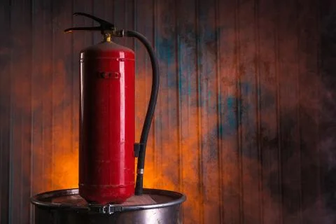 Fire extinguisher on old rusty barrel Foto stock