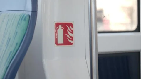 Fire extinguisher safety sign inside modern train carriage showing caution. Stock Footage 332141025