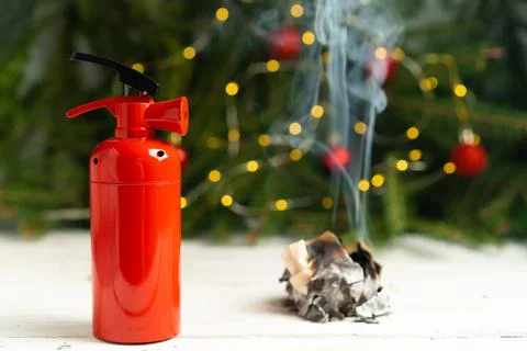 The fire extinguisher stands on a white table, against the background of a Foto stock
