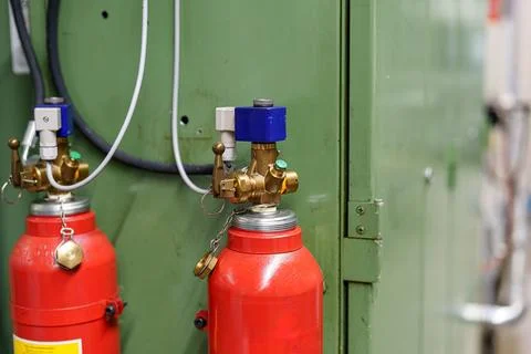 Fire extinguishers installed in a workspace for safety during operations Stock Photos