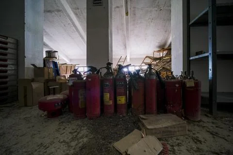 Fire extinguishers kept with materials and instruments in warehouse Stock Photos