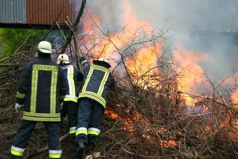 Fire fighter in action big fire with everything else burning next to it Stock Photos