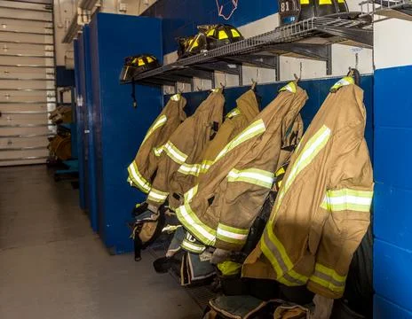 Fire fighter coats on hooks. Stock Photos