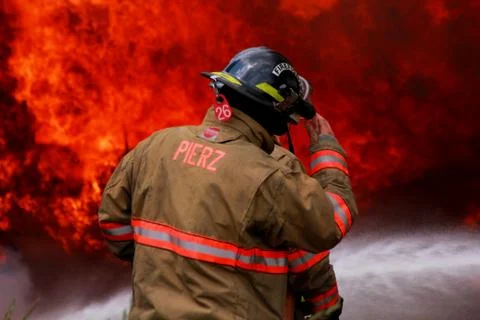 Fire Fighter in Front of Flames Stock Photos