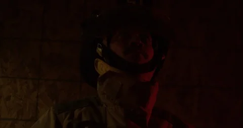 Fire Fighter looks around ceiling in building - close up on face Stock Footage 108820383