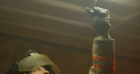 Fire Fighter pulls tape off of lights in industrial building - slow motion Stock Footage 108820048