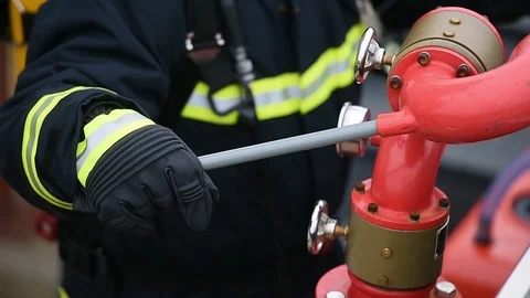 Fire fighter staying in position next to a hydrant 스톡 동영상 120939014
