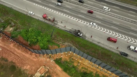 Fire fighter tackles car fire on busy highway Stockbeeldmateriaal 337330443