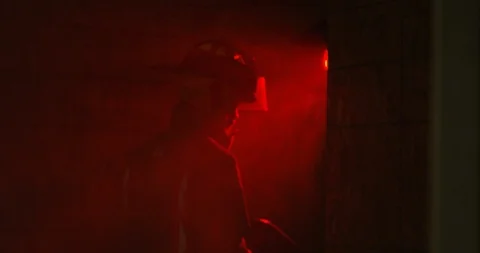 Fire Fighter walking into smoke filled room - from behind Stock Footage 108820043