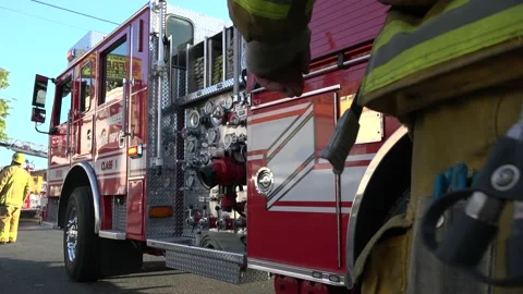 Fire fighters responding to burning building &amp; fire truck on standby Video stock 209723193