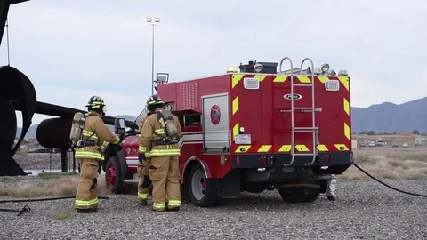 Fire fighters returning fire hoses to reels on fire engine during exercise Video stock 98933583