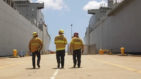 Fire fighters walking away on dock between two ships Video stock 116489809