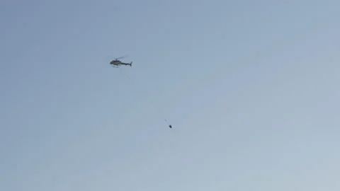 Fire fighting helicopter flying over beach resort Stock Footage 145924555