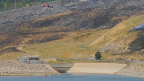 Fire fighting helicopters getting water to fight a fire. Stock Footage 93608528