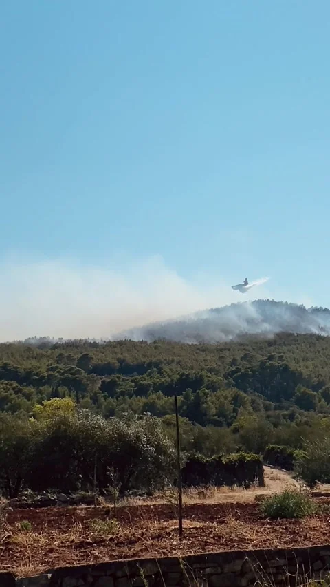Fire fighting plane extinguishing a forest fire on the island of Hvar, Croatia 動画素材 203841173