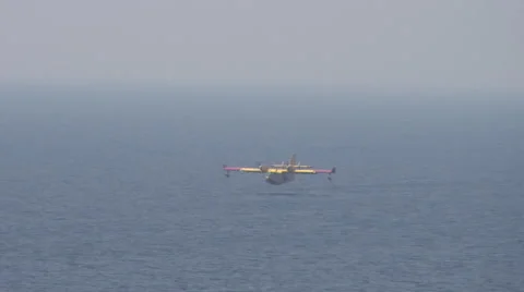 Fire-fighting plane tanking up water in  the sea. Clip 1. Stock Footage 44560573