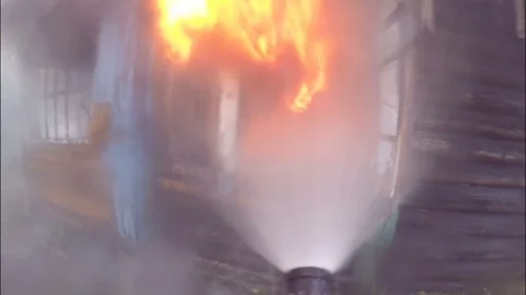 The fire. Firefighters extinguish the fire through the window of the building. Video stock 80449737