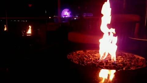 Fire in firepit, reflection and Santa Monica Pier ferris wheel Stock Footage 140945429