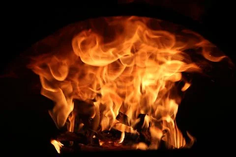 Fire in the fireplace on a dark background Stock Photos