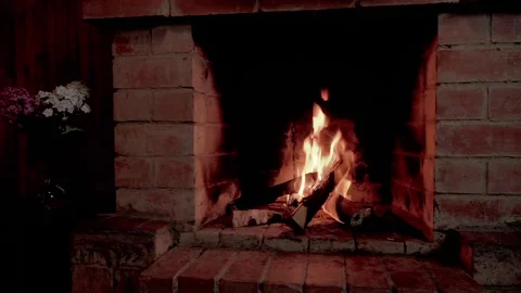 The fire in the fireplace gives warmth and comfort, casting a dim light on a Stock Footage 138201984