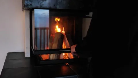 Fire in the fireplace.man closes a burning fireplace Stock Footage 246979918