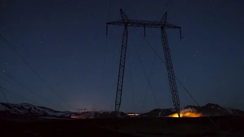 Fire flames arising from the bottom of electricity pylon near snowy mountains Video stock 73011938