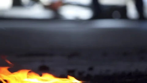 Fire in foreground as life continues out of focus on the street behind Stock Footage 104058057
