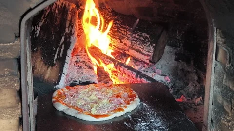 The fire glows warmly inside the brick oven, ready for fresh pizza. Stock Footage 320870351