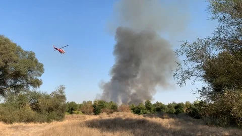 Fire Helicopter drops water in fire fight Stock Footage 117807858