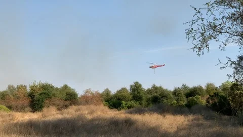 Fire helicopter fights fire with water drop Stock Footage 117807770