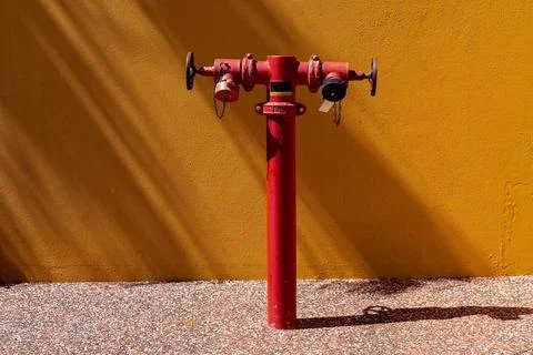 Fire Hydrant Against Orange Wall Stock Photos