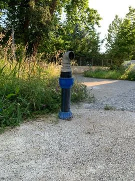 Fire hydrant on concrete pad, made of metal and plastic, with curved spigot  Stock Photos