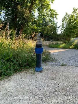 Fire hydrant on concrete pad, made of metal and plastic, with curved spigot Stock Photos