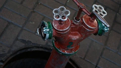 Fire hydrant connected to an open hatch in the city. Old red fire hydrant. Close Vidéo 122765756