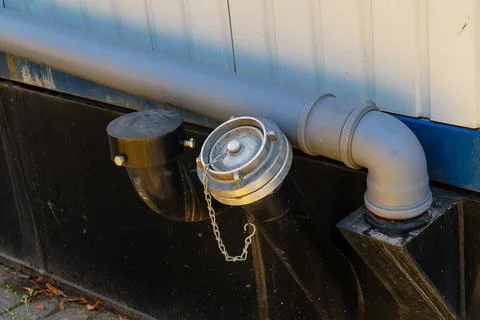 Fire hydrant connection located next to building wall Stock Photos