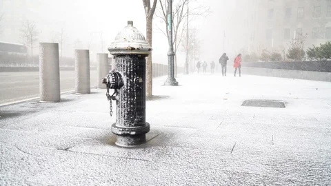 Fire Hydrant in foreground as people battle against snow blizzard, New York Stock Footage 120700302
