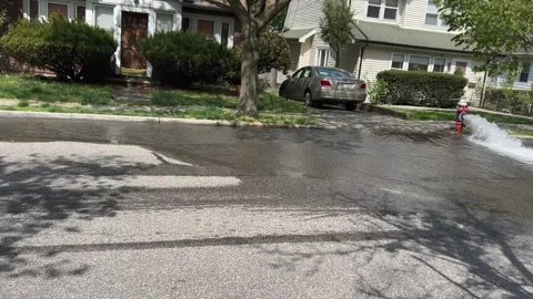 Fire hydrant gushing water flow in the streets - 4K Handheld Pan Stock-Footage 240964578