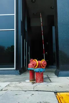 Fire hydrant with a long hose in front of building Stock Photos