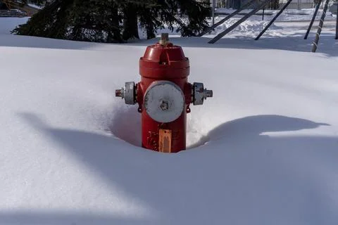 A fire hydrant partly buried by snow in Yellowknife, Canada Stock Photos