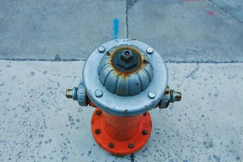 Fire hydrant placed on a concrete surface with visible rust and wear during.. Stockfoto's