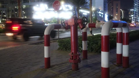 A fire hydrant by the road, with red poles, night scene, stop sign Stock Footage 308642365