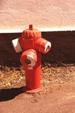A fire hydrant sitting on the side of a building Stock Photos