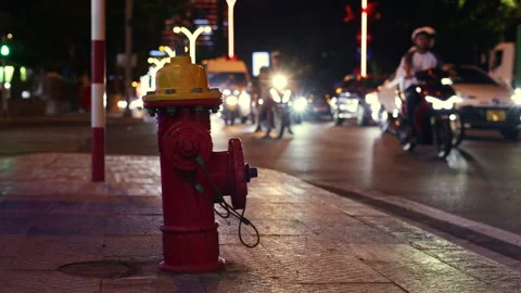 Fire hydrant standing on a city sidewalk during night traffic Stock Footage 336099439