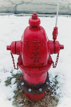 Fire hydrant stands in snow during winter season near a city street with ic.. Stock-Fotos