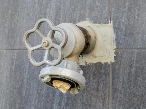 Fire hydrant with stone into it on an outer wall of the building. Vandalism. Foto stock