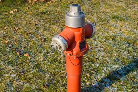 Fire hydrant surrounded by green grass. Red fire hydrant on the side of the road Stock Photos