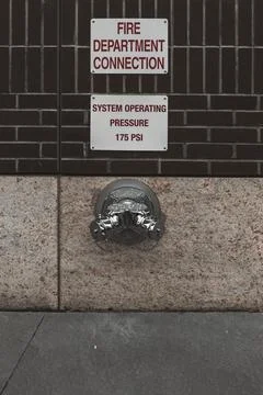 Fire hydrant water pipe, mounted in a building wall. Manhattan USA Stock Photos